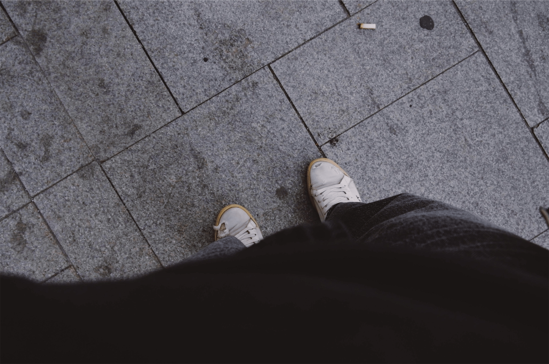 peuk op de grond voor de schoenen van een roker